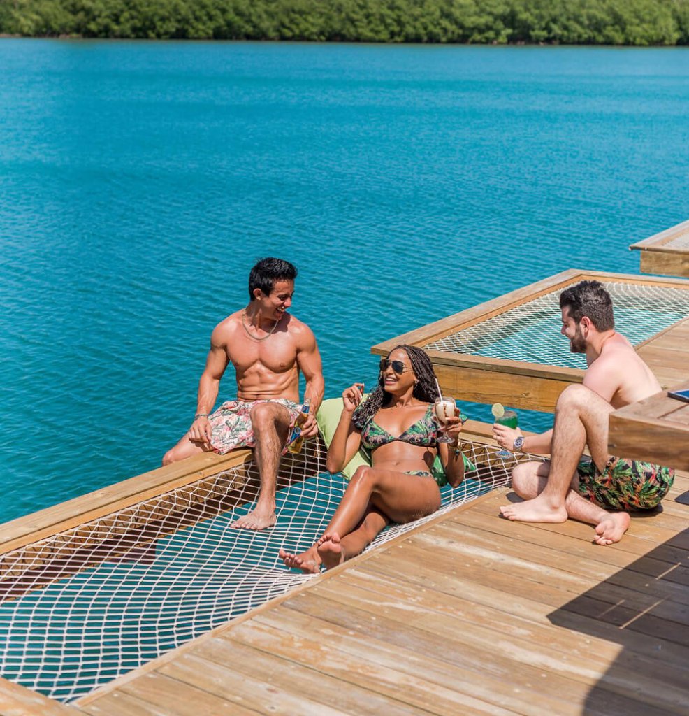 Three friends in swimsuits on a pier | Design your custom swimsuit